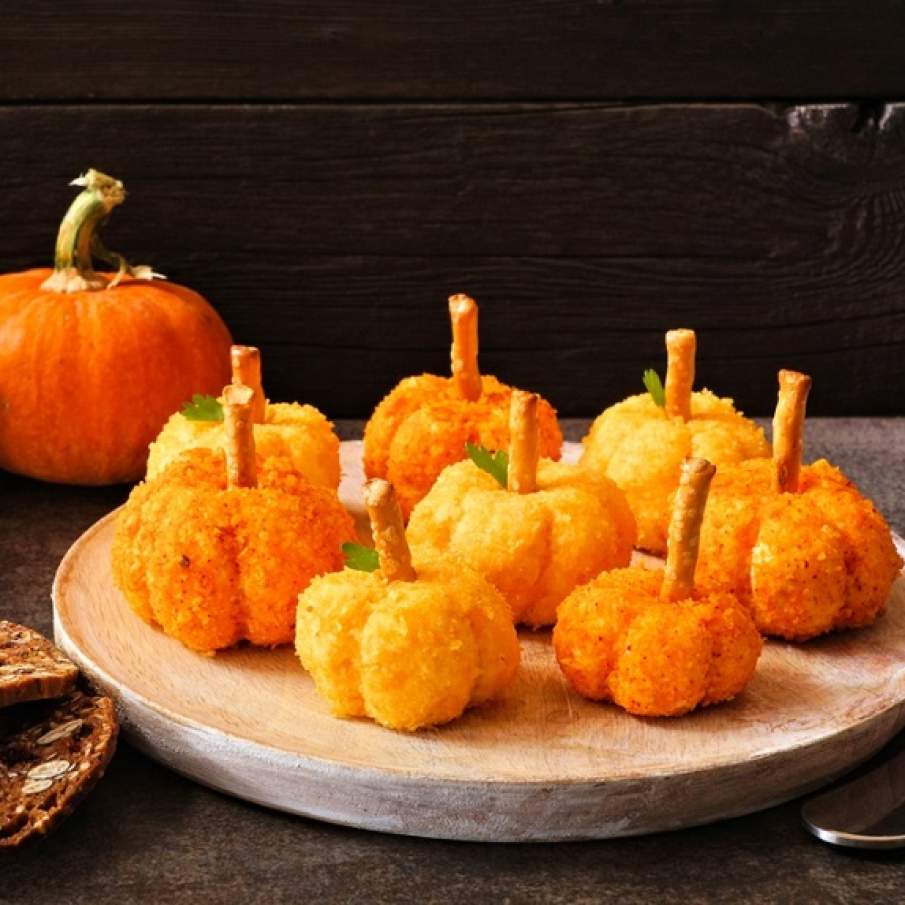 Aperitive de toamnă demne de o petrecere tematică sau chiar de Halloween: bile de brânză în formă de dovleac decorate cu sticksuri și frunzulițe de pătrunjel